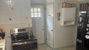 Eine Küche mit Edelstahlherd, Kühlschrank und Waschmaschine.