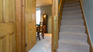 A wooden door leading to a carpeted staircase with a wooden handrail. - Cottage close To Coastal Path & Puffin Island | Pass the Keys (Beaumaris)