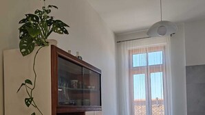 A compact kitchen with a dining area, featuring a cabinet with glass doors, a dining table with chairs, and a window with sheer curtains. - LA CASINA Panoramic apartment in the countryside very close to the village (Amelia)
