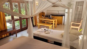 Un dormitorio con cama con dosel, una mesa de madera y un banco.