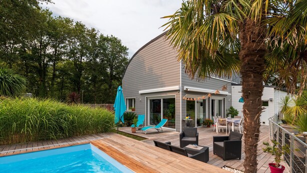 A modern house with a swimming pool, patio furniture, and a covered outdoor area. - Room 'Houat' with Shared Terrace, Wi-Fi, and Air Conditioning (PLOEREN)