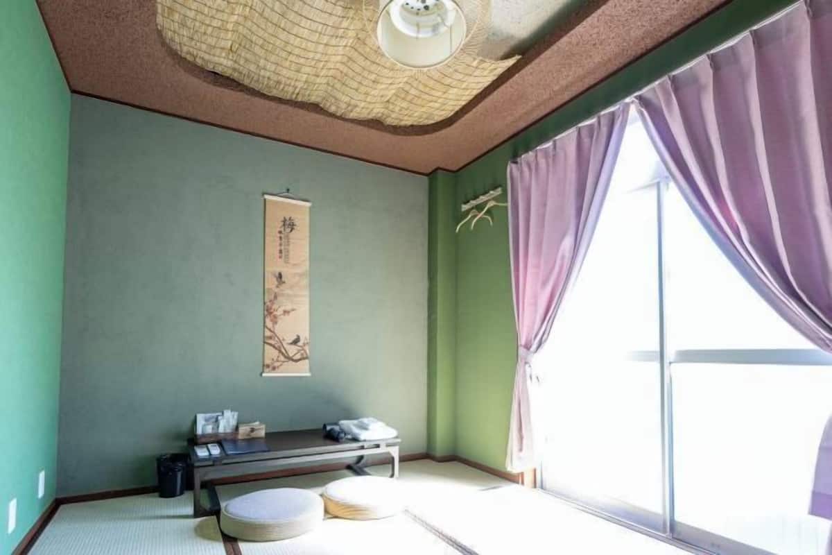 A traditional Japanese room with tatami flooring, a low table, and a sliding door.