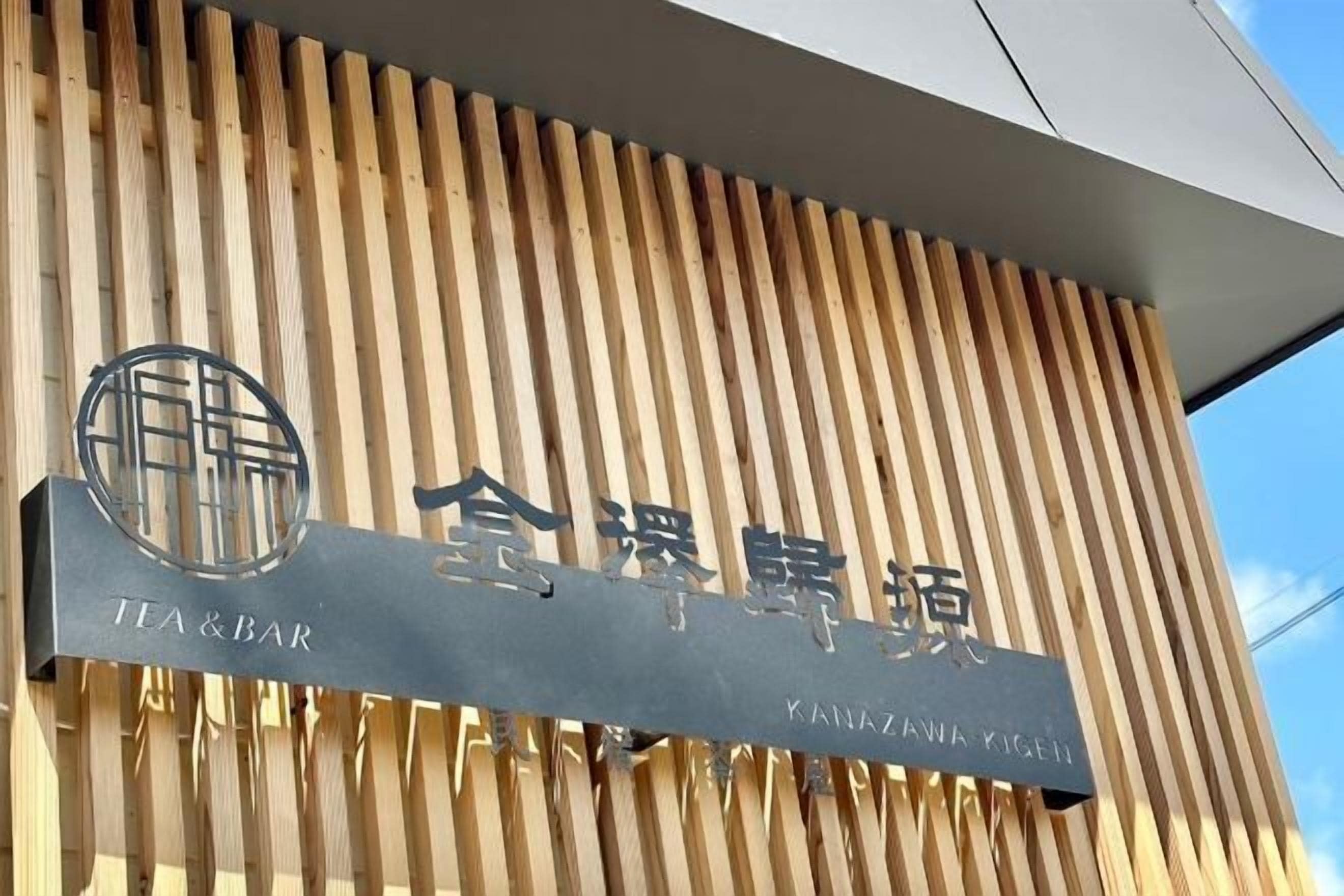 Un letrero con la inscripción 'TEA & BAR' y 'KANAZAWA KIGEN', que indica un establecimiento de té y bar.