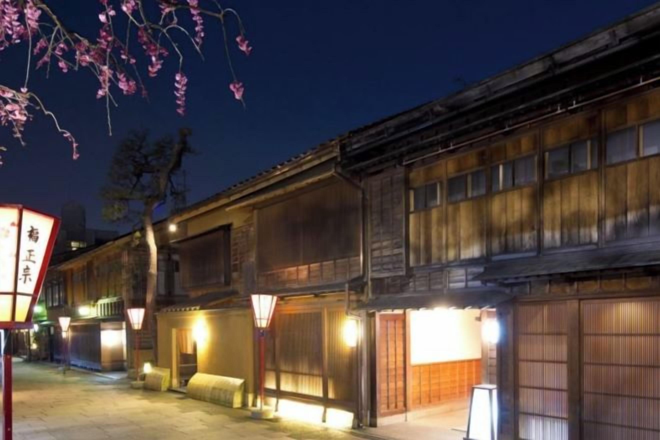 A traditional Japanese building with wooden facades and illuminated windows at night.