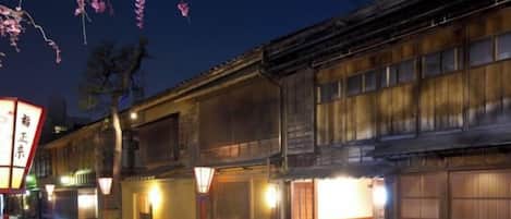 A traditional Japanese building with wooden facades and illuminated windows at night.