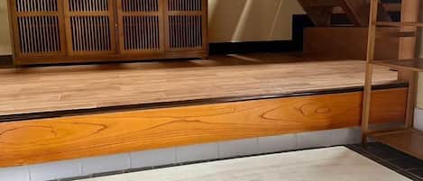 A wooden floor with a built-in bench, a staircase, and a wooden cabinet.
