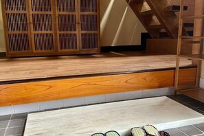 A wooden floor with a built-in bench, a staircase, and a wooden cabinet. - kanazawakigen (Kanazawa)