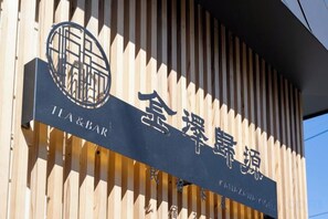 Un cartel con caracteres chinos y la inscripción 'TEA & BAR', que indica un establecimiento de té y bar.