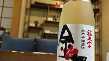 Een fles met een etiket waarop Japanse karakters en een bloemendessin staan.