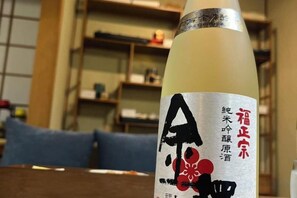 Eine Flasche mit Etikett, verziert mit japanischen Schriftzeichen und einem floralen Muster.