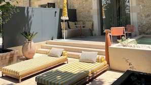 A stone building with a balcony, outdoor seating, and a pool area. - La Maison Verchant (Montpellier)