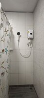 Habitación doble | Baño | Ducha, artículos de higiene personal gratuitos, zapatillas y toallas