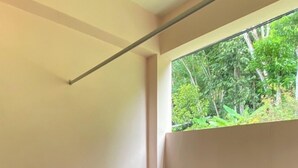 A small, enclosed room with a tiled floor and a window overlooking greenery. - Makorn Nonkleng (Thung Song)
