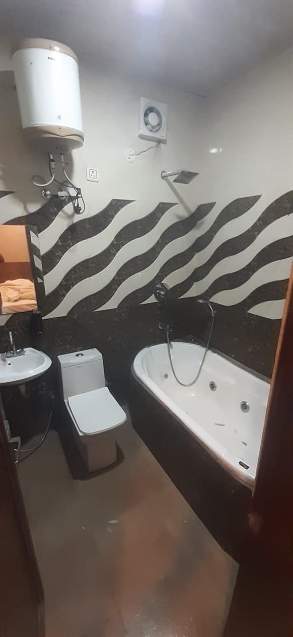 A bathroom with a zebra-patterned wall, a white sink, a toilet, and a bathtub.