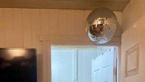 A bathroom with a white sink, a round mirror, and a disco ball. - Air conditioned home w/ full kitchen, TV & parking (Puerto Viejo de Talamanca)