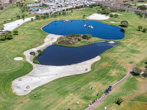 An aerial view of a golf course with two ponds, sand bunkers, and a walking path. - Par Excellence Villa (Langebaan)
