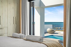 A bedroom with a view of the sea, a pool, and a large stone bowl. - Shelley Point Beach Villa (St. Helena Bay)