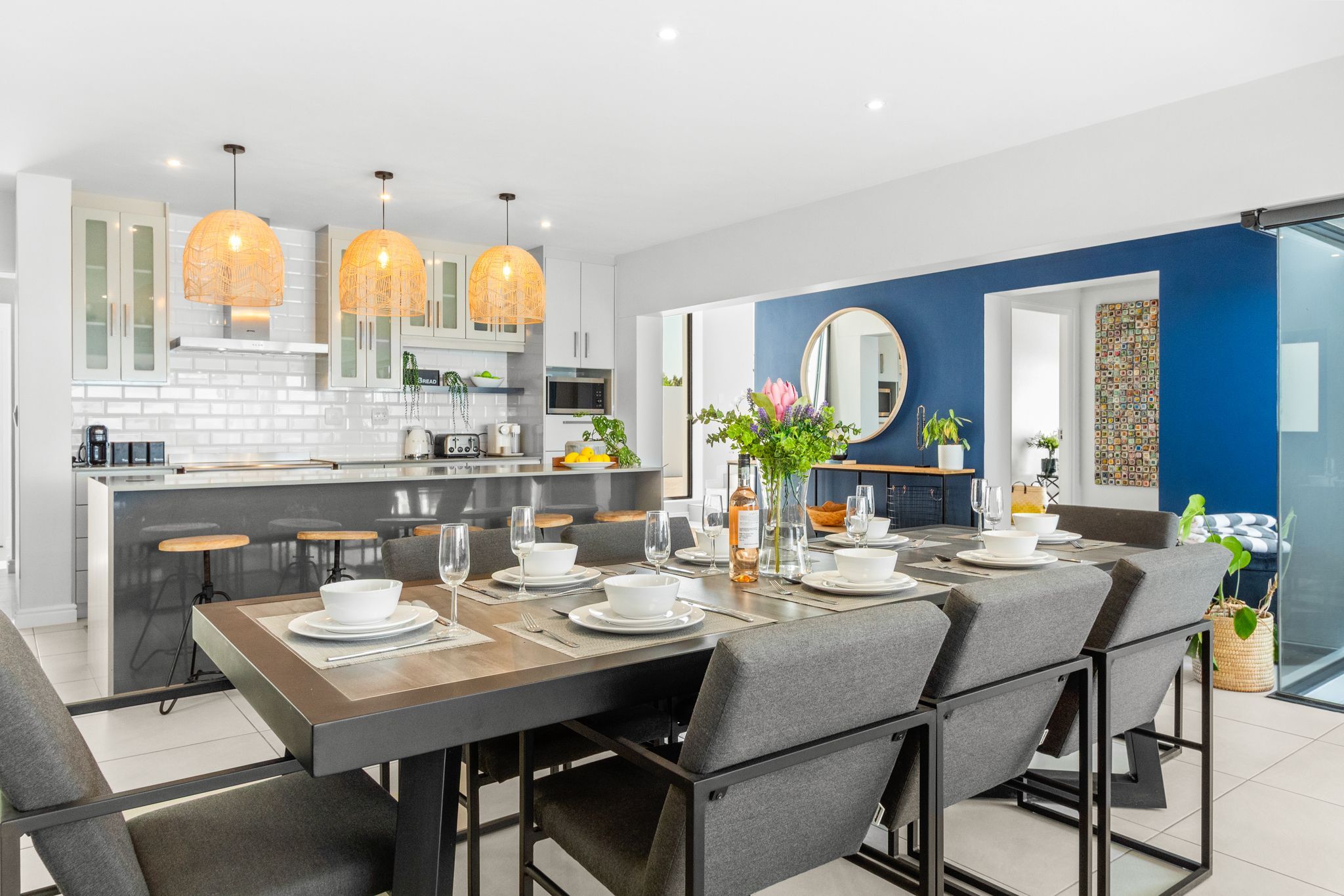 A modern kitchen with white cabinets, a central island, and pendant lighting.