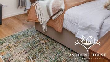 Une chambre à coucher avec un grand lit, un bureau, une chaise, une télévision et une fenêtre avec des rideaux.