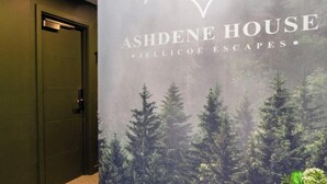 A hallway with a poster of Ashdene House, featuring a forest scene and the hotel's logo. - Sheep Room 11 -Peaceful Double - New Forest (Dibden Purlieu)