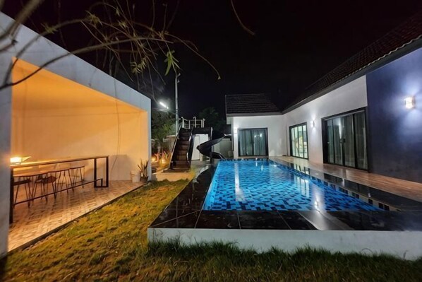 Une maison moderne dotée d’une piscine, d’un escalier et d’un coin repas.