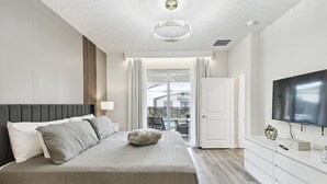Habitación de hotel moderna con una cama grande, televisión y vistas al exterior.