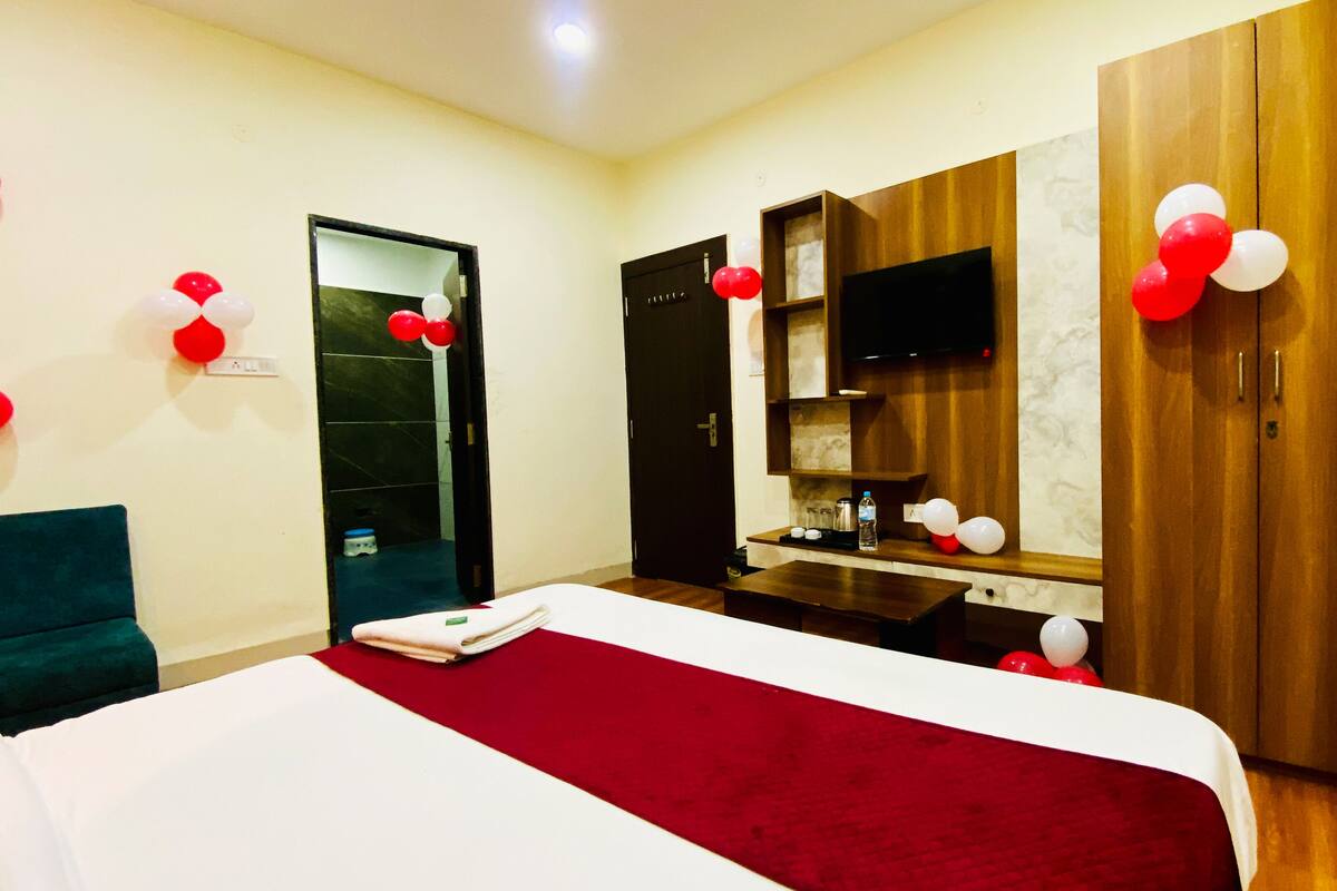 A hotel room with a bed, a desk, a TV, and a wardrobe.