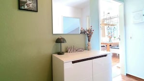 Una habitación con un armario blanco, un espejo y dos cuadros en la pared.