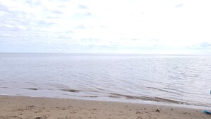 A beach with calm waters and a clear sky. - Coastal Charm in Caissie Cape Beach Community (Grande-Digue)