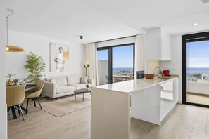 Een modern appartement met een eethoek, bank en keukeneiland.