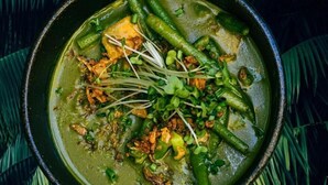 A bowl of green curry with vegetables and sprouts, served in a black pot. - The Rock Inn Hotel (Pub & Restaurant) (Taunton)