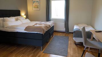Una habitación de hotel moderna con una cama grande, un escritorio y una silla.