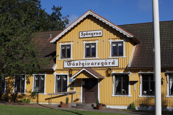 Un edificio amarillo con un letrero que dice 'Spångens Gästgivaregård'.