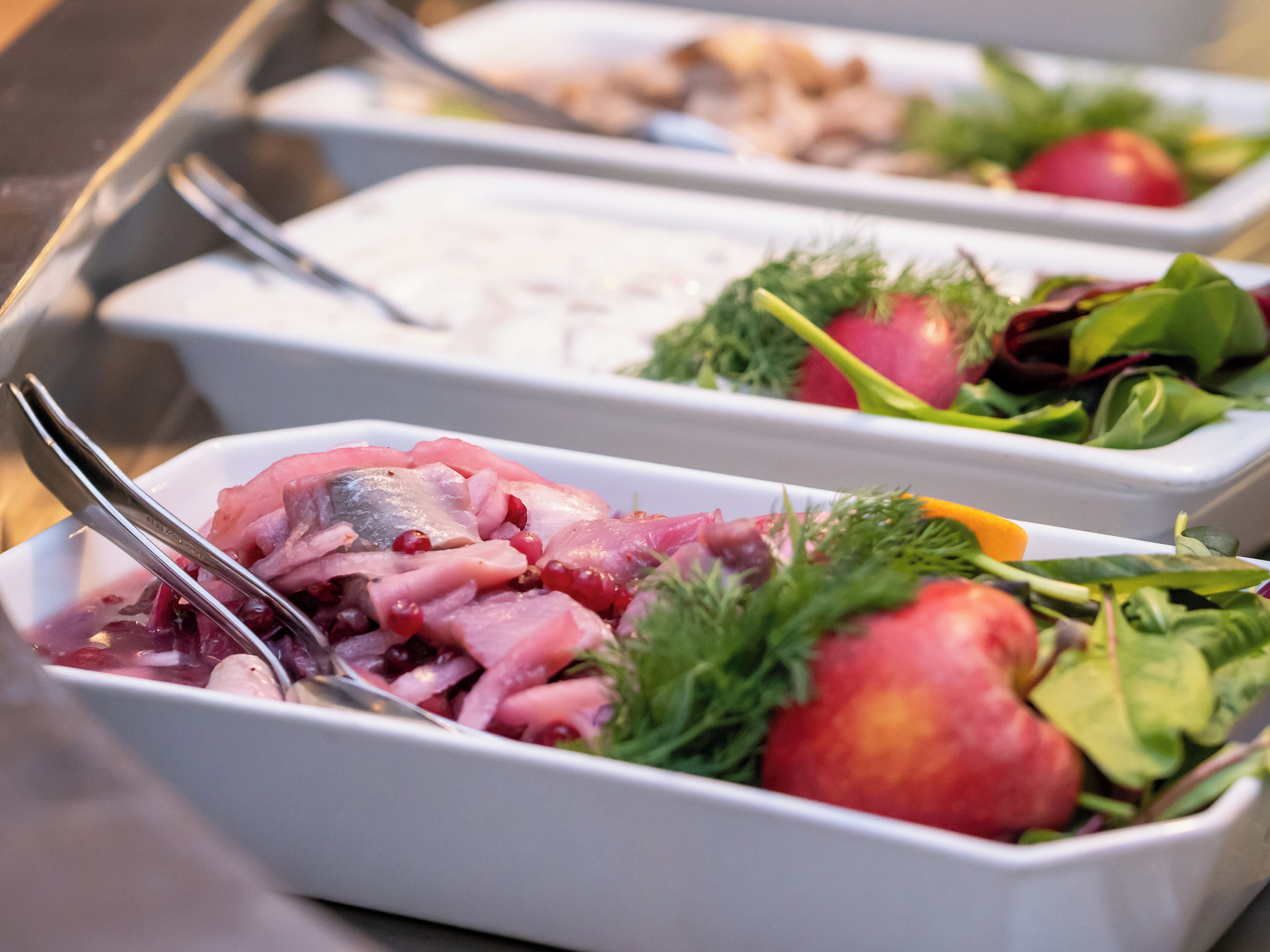 Un bufé con diversos platos, incluyendo mariscos, frutas y verduras.