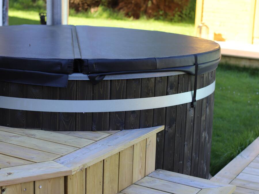 Une terrasse en bois avec des marches menant à un jacuzzi.