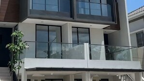 A multi-story building with a balcony, staircases, and a plant. - winner house (North Jakarta)