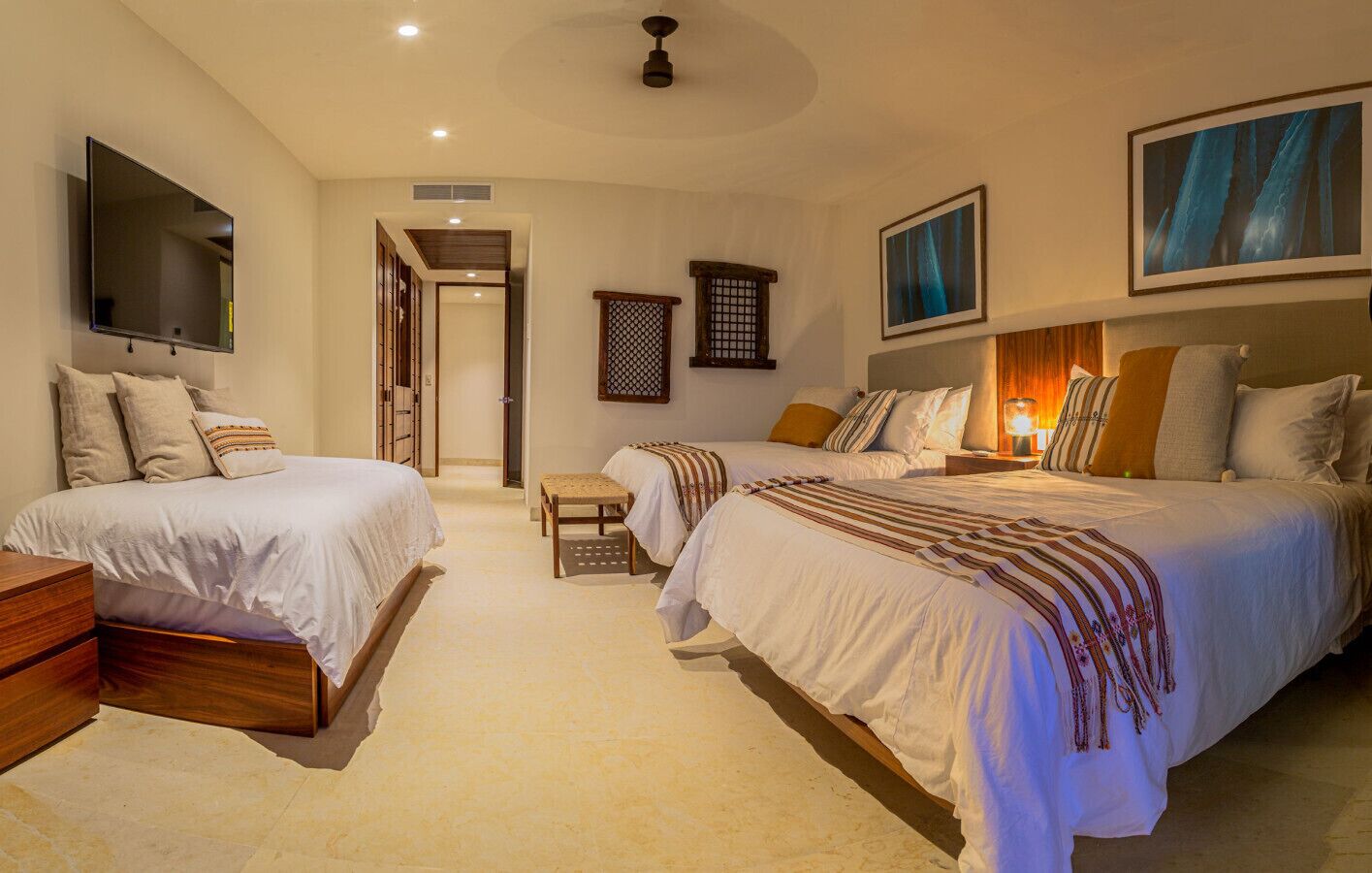 A hotel bedroom with two beds, a TV, and a small table.