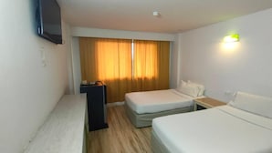 A hotel room with a bed, a bedside table, a TV mounted on the wall, and a window with curtains. - INTERTOWER HOTEL (Su-ngai Kolok)