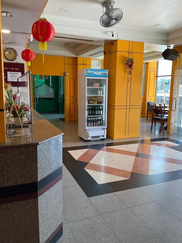 A hotel lobby with a reception desk, a beverage vending machine, and a check-in counter. - INTERTOWER HOTEL (Su-ngai Kolok)