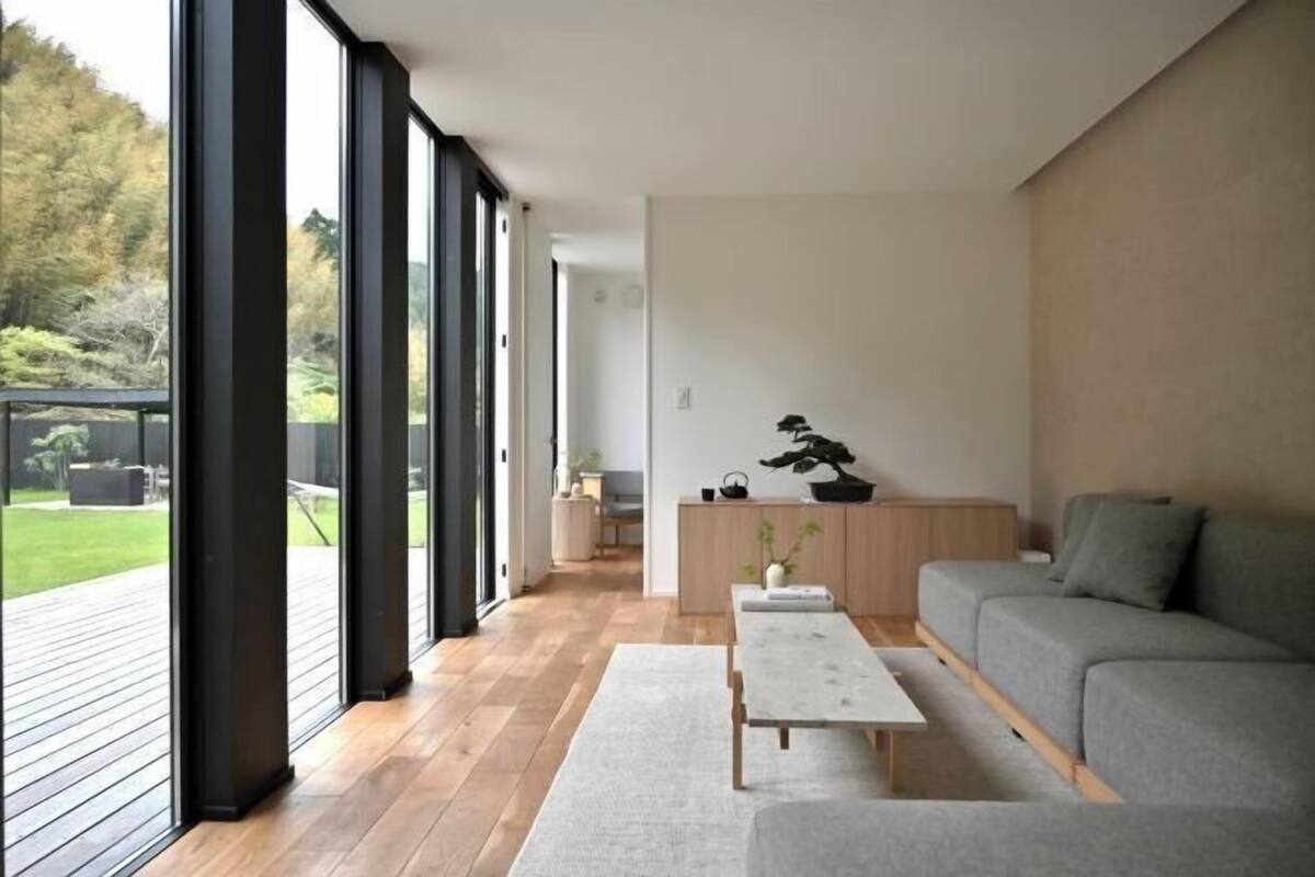 Ein modernes Wohnzimmer mit einer Couch, einem Couchtisch und einer Essecke mit Tisch und Stühlen.