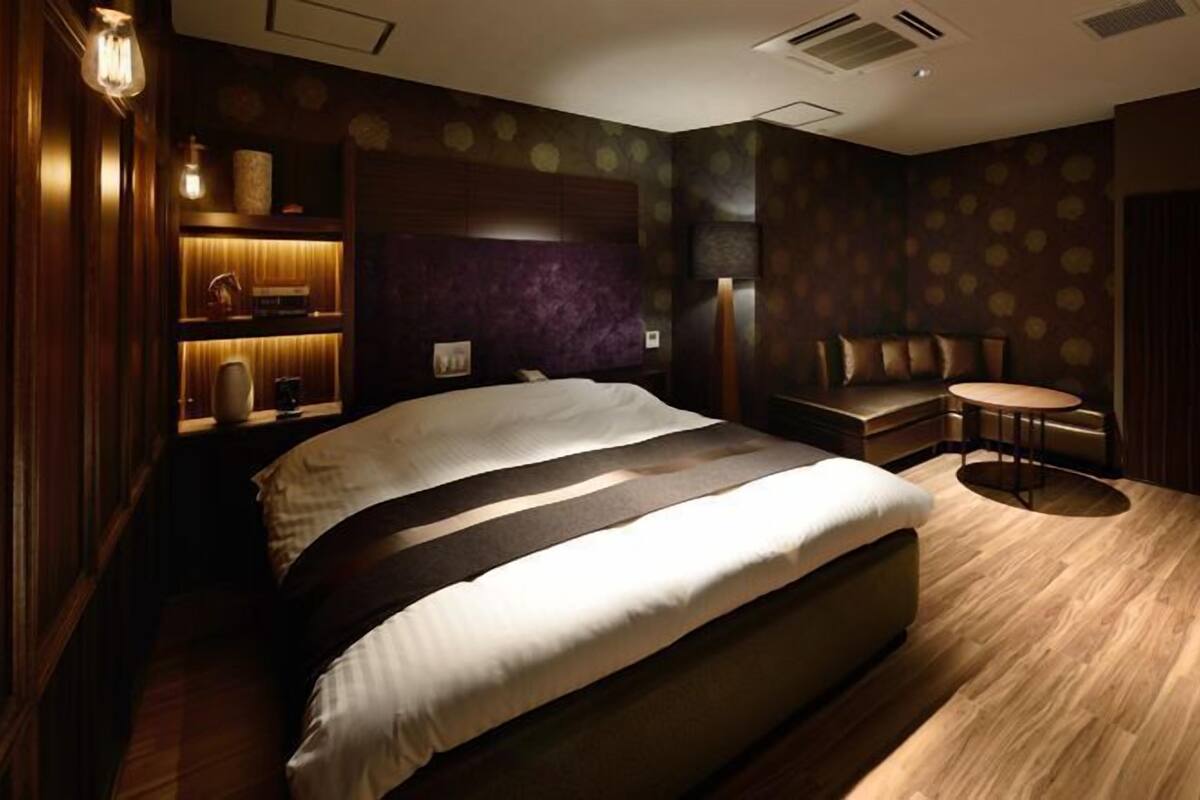 Una habitación de hotel moderna con una cama grande, una zona de estar y una mesita.