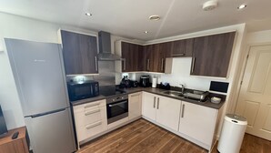 A modern kitchen with a stainless steel refrigerator, microwave, oven, and sink.
