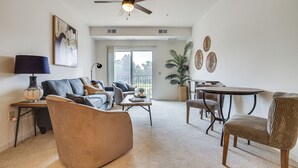 Una sala de estar con sofá, sillón, mesa de centro y un comedor con mesa y sillas.