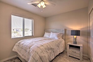 A bedroom with a bed, a nightstand with a lamp, a ceiling fan, and a window with blinds. - 3 Mi to Beach & Boat Launch: Lake Havasu Home! (Lake Havasu City)