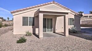 A single-story house with a beige stucco exterior, a tiled roof, and a front entrance with a door and windows. - 3 Mi to Beach & Boat Launch: Lake Havasu Home! (Lake Havasu City)