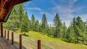 Eine Holzterrasse mit Blick auf einen bewaldeten Hügel.