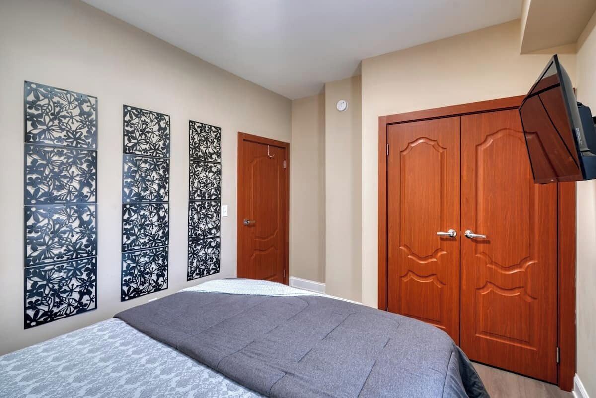 Ein Schlafzimmer mit einem Bett, einem Kleiderschrank und dekorativen Wandverkleidungen.