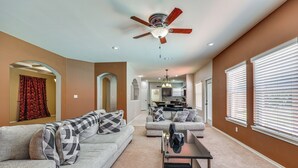 A spacious living room with a ceiling fan, a sofa set, and a dining area in the background. - Private Theater & Pool: Spacious Mission Home (Mission)