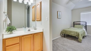 A bedroom with a bed, a nightstand, a mirror, and a window with blinds. - Private Theater & Pool: Spacious Mission Home (Mission)
