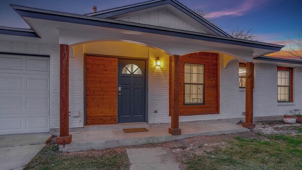 A modern house with a dark front door, wooden accents, and a garage.